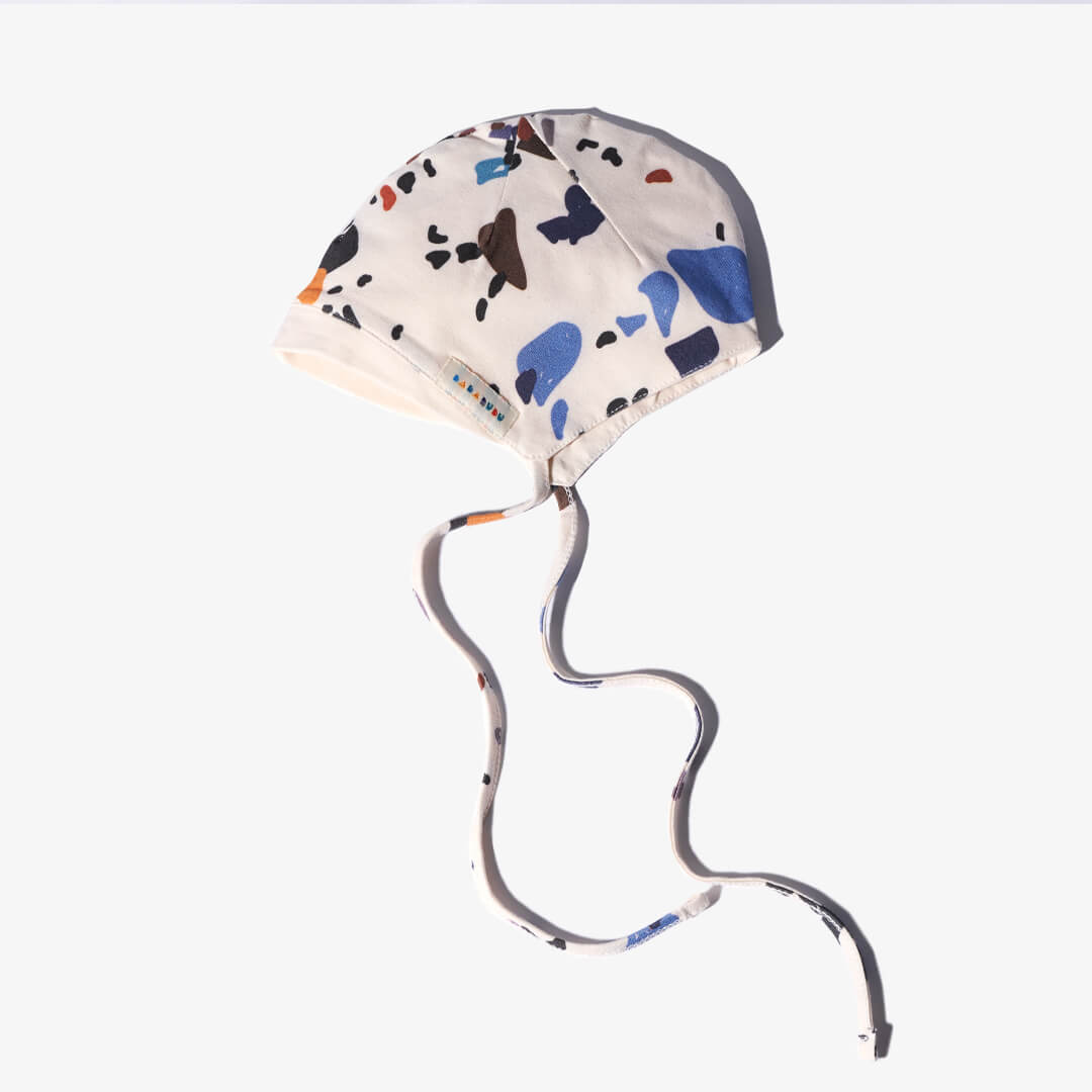 Seitenansicht mit Label der Mütze für Babys aus der DOTS Kollektion