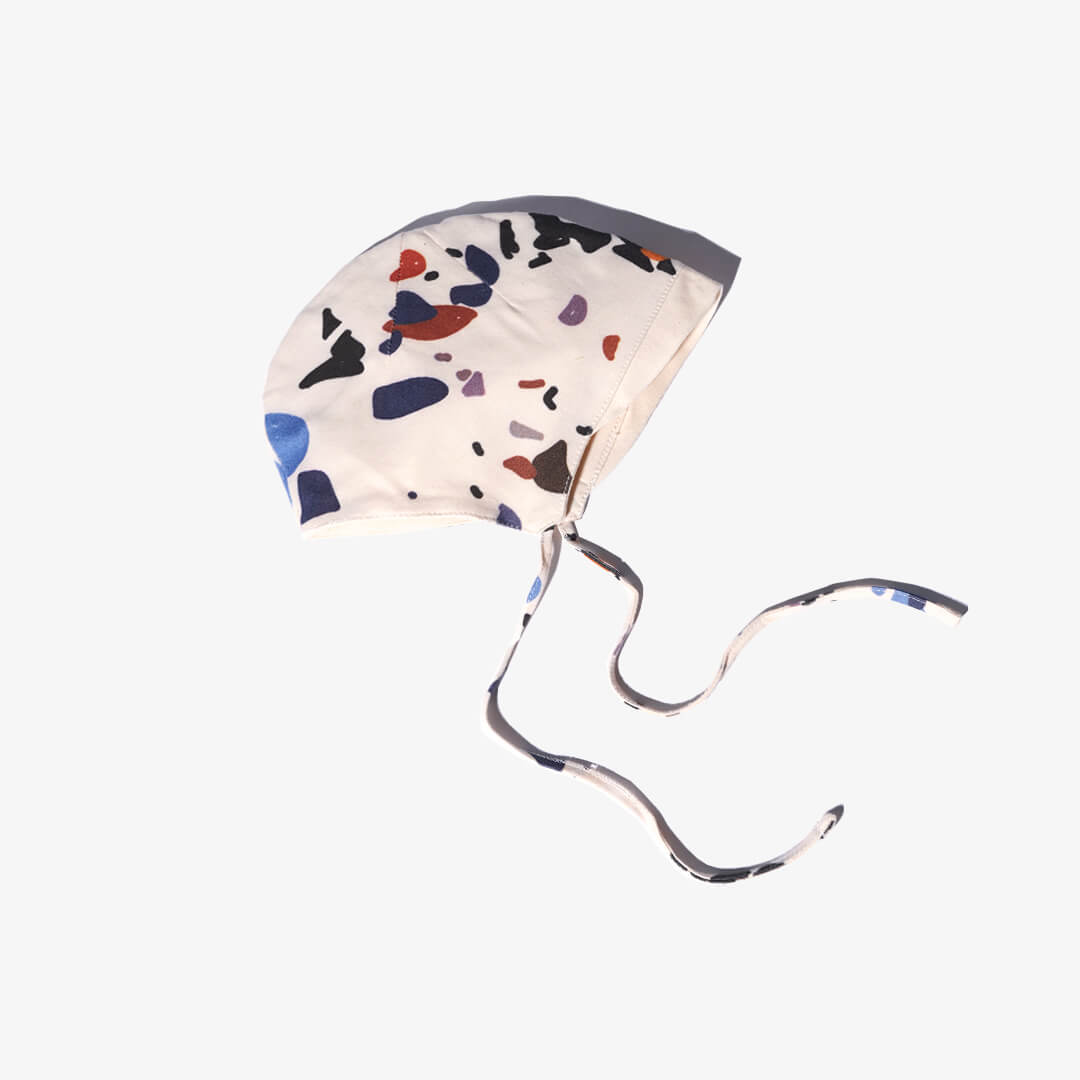 Seitenansicht mit Label der Mütze für Babys aus der DOTS Kollektion