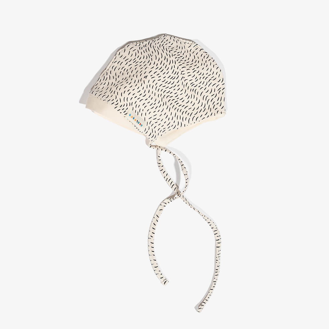 Seitenansicht mit Label der Mütze für Babys aus der FUR Kollektion