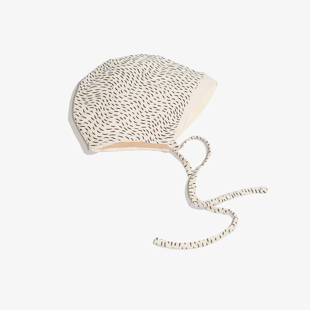 Seitenansicht mit Label der Mütze für Babys aus der FUR Kollektion